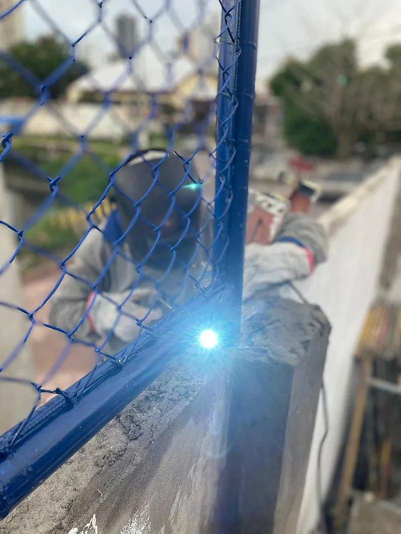 Profissional soldando a estrutura do alambrado