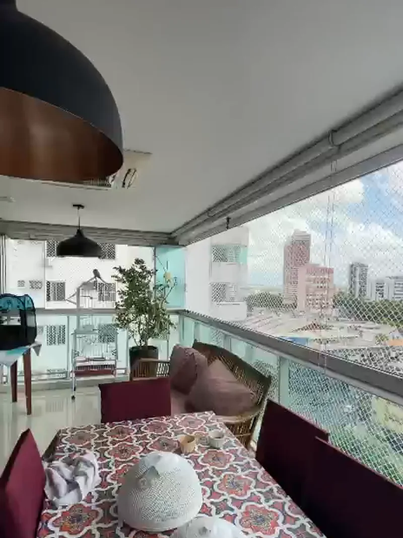 Sacada com vidro e tela de proteção, vista para a cidade
